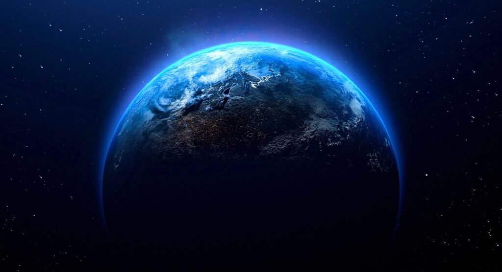 Blue Earth viewed from space with a glowing atmosphere and star-filled background, showing the planet partially illuminated against the darkness of the cosmos.