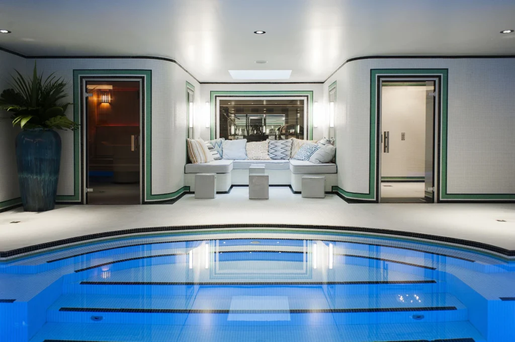 t: Indoor swimming pool and spa lounge at Hôtel Eiffel Blomet in Paris, with blue tile, sauna and cushioned seating.
